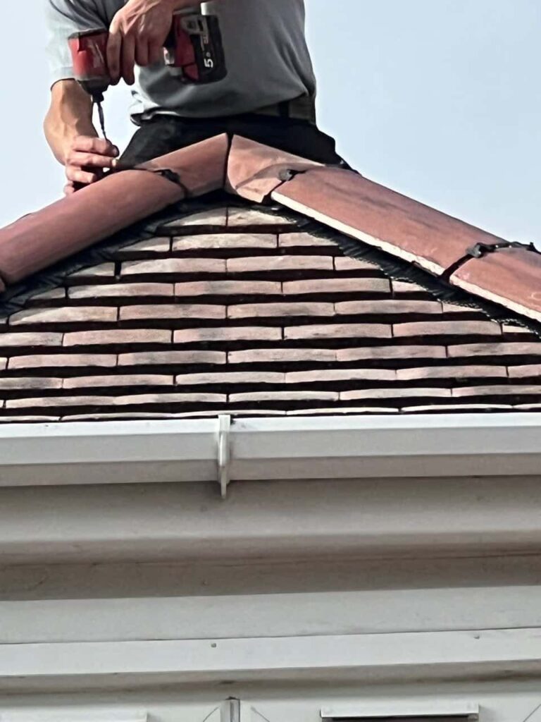 This is a photo of one of the operatives of Knightsbridge Roofing Repairs installing new ridge tiles